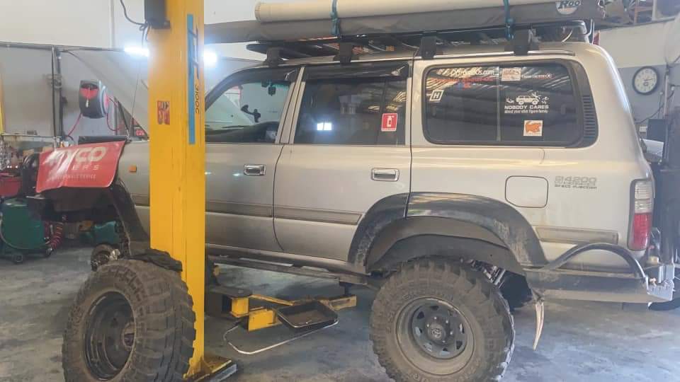 A lifted 4WD wagon up on the hoist inside the Roger's Mechanical Services workshop